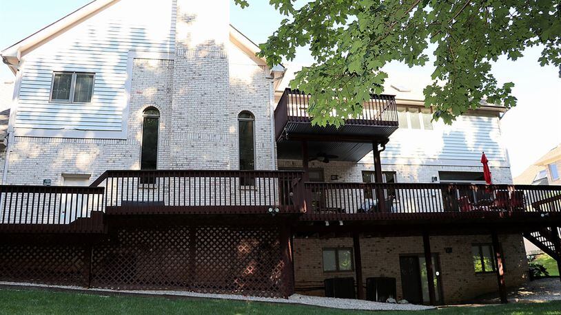 A large balcony deck overlooks the back yard; a smaller balcony deck is accessible from one of the second-floor bedrooms.