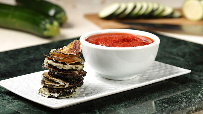 Fresh slices of zucchini, coated with a light dusting of potato starch, transform into crispy chips when deep fried. Marinara sauce makes a zesty dip. (Abel Uribe/Chicago Tribune/TNS)
