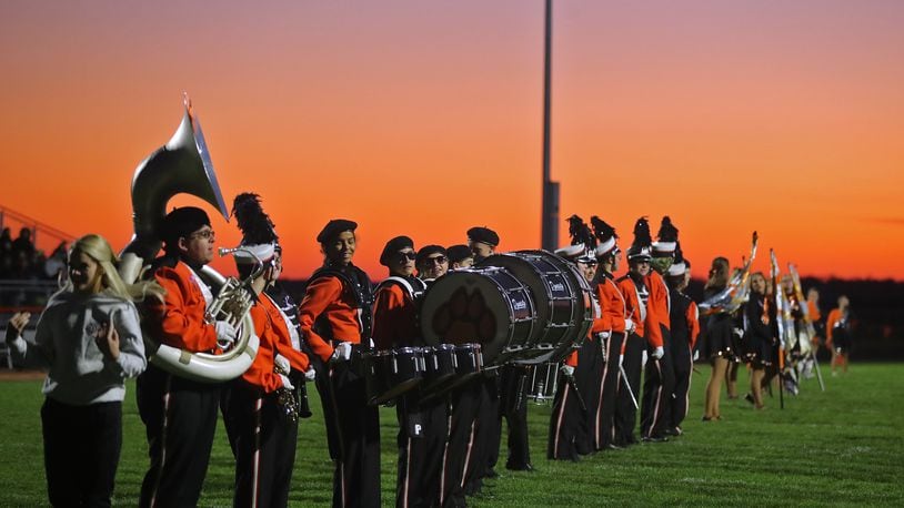 The sun sets behind the West Liberty-Salem band as they wait for the football team to take the field Friday. BILL LACKEY/STAFF