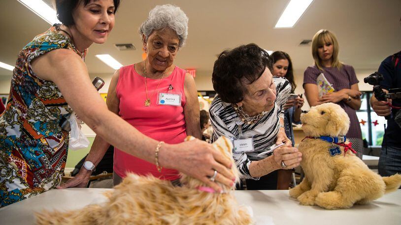 Karen Gilbert, vice president of education and quality assurance at Alzheimer’s Community Care, left, patient Aurora, middle, and Helen, right, interact with a robotic cat and dog at Alzheimer’s Community Care’s facility in Boca Raton, Fla. on Thursday, Aug. 2, 2018. (Yutao Chen/Sun Sentinel/TNS)