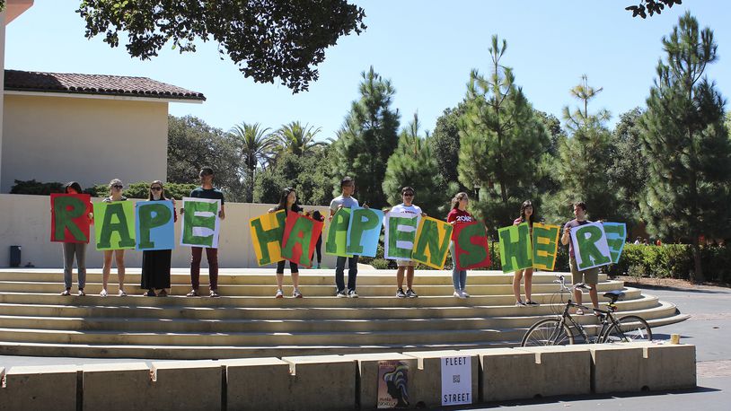 In this Sept. 16, 2015 photo provided by Tessa Ormenyi, students hold up a sign about rape at White Plaza during New Student Orientation on the Stanford University campus in Stanford, Calif. Stanford University considers itself a national leader on preventing and handling sexual assaults, but students have complained that the school isn’t doing enough and have drawn attention to the issue by holding demonstrations. (Tessa Ormenyi via AP) MANDATORY CREDIT
