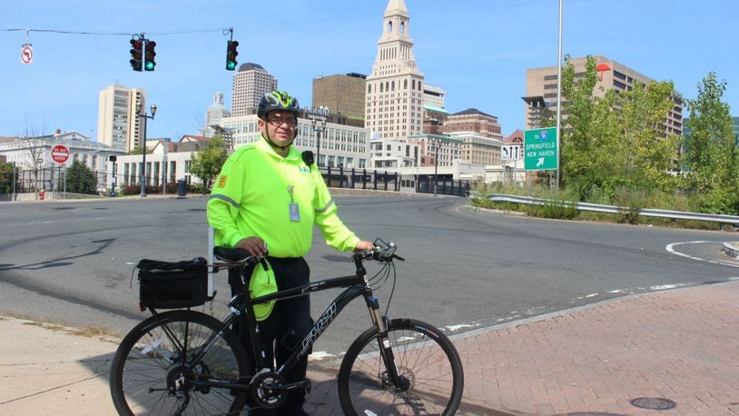 Eddie Zayas, a safety ambassador for the Hartford Business Improvement District, poses during a patrol of downtown streets on Sept. 12, 2017. Zayas is part of a program that provides free roadside assistance to bicyclists who break down in Connecticut's capital city (AP Photo/Pat Eaton-Robb)