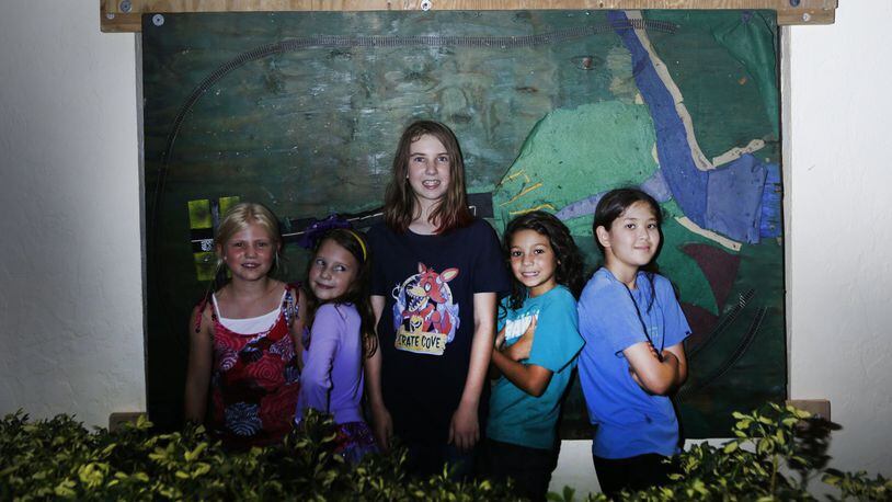 From left to right, Lucy Nacarrato, Elina Barnhart, Olivia Barnhart, Jasmine McDermott, and Shaylen Costello stand in front of the shutter that was installed at Dave Barnhart’s house Friday, October 7, 2016 in Tequesta. The shutter was made of a train track from one of Barnhart’s neighbors. The neighbors helped Barnharts shutter their house. The Barnharts made it through the storm fine. (Yuting Jiang / The Palm Beach Post)