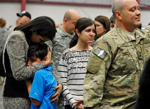 South Carolina Gov. Nikki Haley, left, comforts her son, Nalin, 10, and her daughter, Rena, 14, as her husband, Capt. Michael Haley, right, gets ready for a deployment ceremony.
