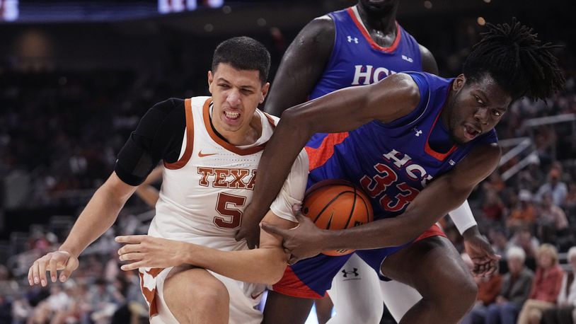 Texas forward Kadin Shedrick (5) and Houston Christian forward Michael Imariagbe (33) fight for control of the ball during the second half of an NCAA college basketball game in Austin, Texas, Saturday, Dec. 9, 2023. (AP Photo/Eric Gay)