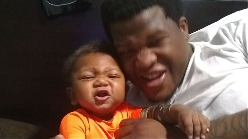 This photo provided by Avontea Boose shows her 9-month-old son, Tristan Roberson, with his father, Jemel Roberson. Jemel Roberson, 26, was killed by a Midlothian, Illinois, police officer early Sunday, Nov. 11, 2018, as he subdued a gunman who shot several people at Manny's Blue Room Lounge in Robbins, a suburb of Chicago. Roberson was armed with a licensed weapon when he was killed.