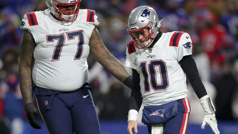 New England Patriots quarterback Mac Jones (10) reacts alongside offensive tackle Trent Brown (77) during the second half of an NFL wild-card playoff football game against the Buffalo Bills, Saturday, Jan. 15, 2022, in Orchard Park, N.Y. (AP Photo/Joshua Bessex)