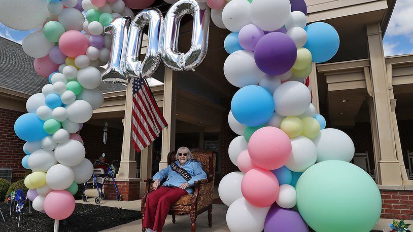 Ruth Bayley, a lifelong Springfield resident and Wittenberg alumni, sits in her seat of honor in front of Hearth and Home care center as she waits for the birthday parade to drive past to celebrate her 100th birthday. BILL LACKEY/STAFF