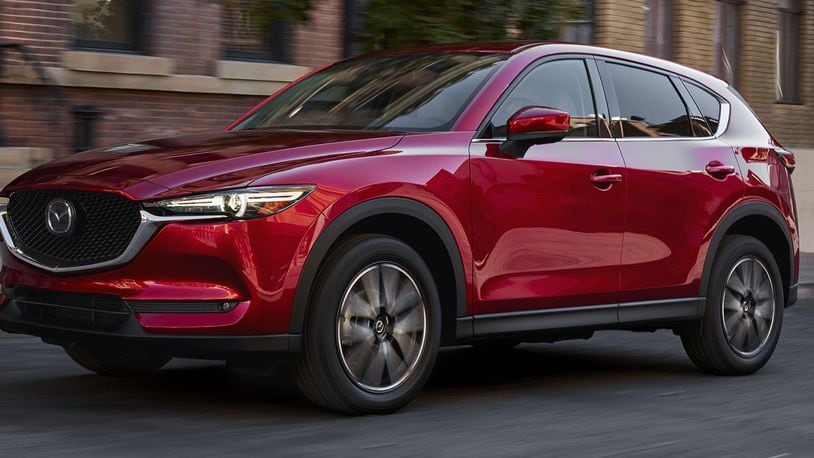 The entry 2017 Mazda CX-5 Sport trim features 17-inch alloy wheels, black cloth-upholstered seats, cruise control, air conditioning, power windows, power mirrors, pushbutton starter, LED headlights, variable intermittent windshield wipers, carpeted floor mats, a 40:20:40 split-folding rear seat, Smart City Brake Support and power door locks. Mazda photo