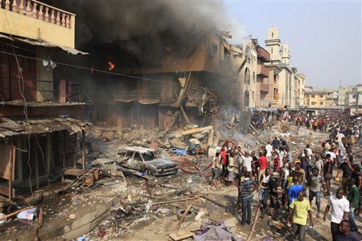 People gather at the site of a fireworks warehouse file on Lagos Island in Lagos, Nigeria, on Wednesday, Dec. 26, 2012.