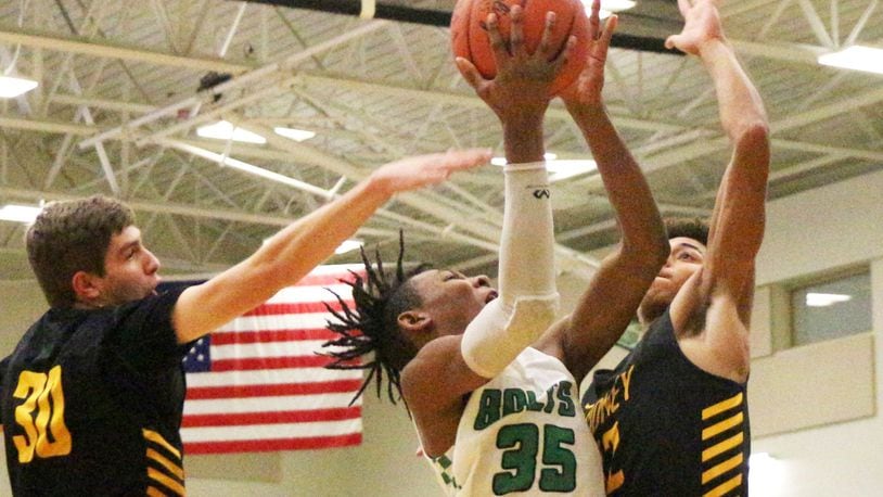 Northmont’s Prophet Johnson (shooting) splits Sidney defenders Trey Werntz (left) and Ratez Roberts. Sidney defeated host Northmont 72-68 in a boys high school basketball game on Tuesday, Jan. 15, 2019. GREG BILLING / CONTRIBUTED