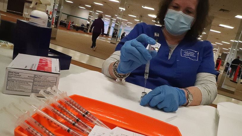 Jennie Router loads a syringe with the COVID vaccine Tuesday at the Clark County vaccine distribution center. BILL LACKEY/STAFF