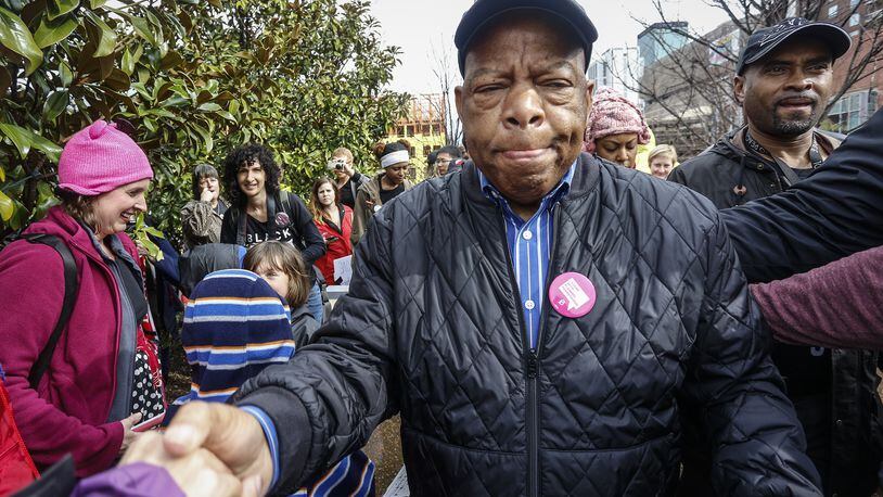 U.S. Rep. John Lewis reaches out to shake the hands of well-wishers as he arrives at the Women's March on Saturday, Jan. 21, 2017, in Atlanta. The rally and march drew thousands of attendees, including , U.S. Rep. John Lewis, who had been at odds with president Donald Trump leading up to the inauguration. At the rally, Lewis told The AP, "We've made progress, but there are forces in America that want to take us back to another time and another place." (AP Photo/Ron Harris)