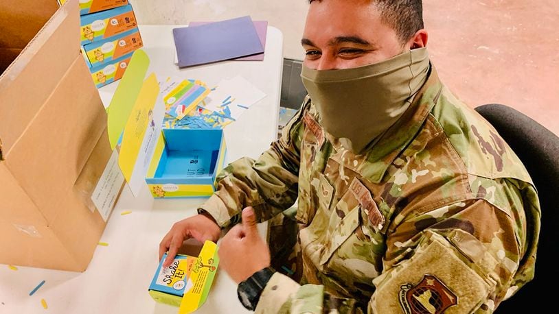 Senior Airman Kwame Robertson of Wright-Patterson Air Force Base’s National Air and Space Intelligence Center builds “Love Them Out Loud” kits during the Dec. 18 volunteer event benefiting the Dayton Metro Library and early childhood literacy. CONTRIBUTED PHOTO