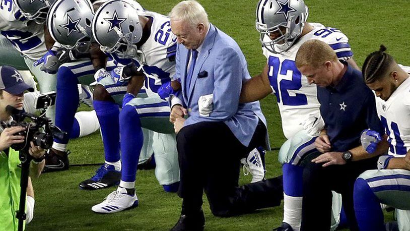 In this Sept. 25, 2017, photo, the Dallas Cowboys, led by owner Jerry Jones, center, take a for the national anthem prior to an NFL football game against the Arizona Cardinals, in Glendale, Ariz. President Donald Trump's clash with the scores of professional football players who knelt during the "Star Spangled Banner" last weekend has set off a heated debate over proper etiquette during the national anthem. (AP Photo/Matt York, File)