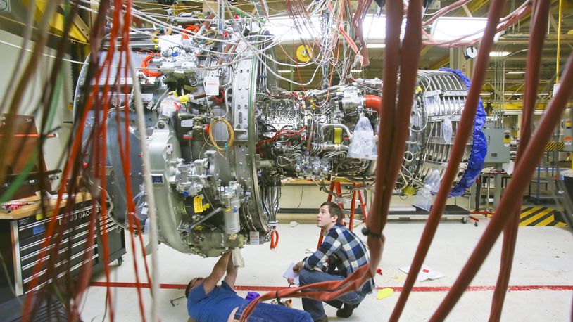 Engineers work on a LEAP commercial jet test engine at GE Aviation in Evendale in this Dec. 19, 2014 photo. The engine, made by CFM, a joint venture between GE and French manufacturer Snecma, will be more fuel efficient and will contain advanced materials, into which GE Aviation has increasingly invested. GREG LYNCH/STAFF