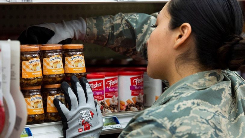 Senior Airman Priscila Salgado from the National Air and Space Intelligence Center on Wright-Patterson Air Force Base helps restock the commissary on base as a volunteer. The commissary asked for the volunteers to help restock shelves to reduce the strain on other workers as they try to keep up with the sudden increase in purchases. (U.S. Air Force photo/Wes Farnsworth)