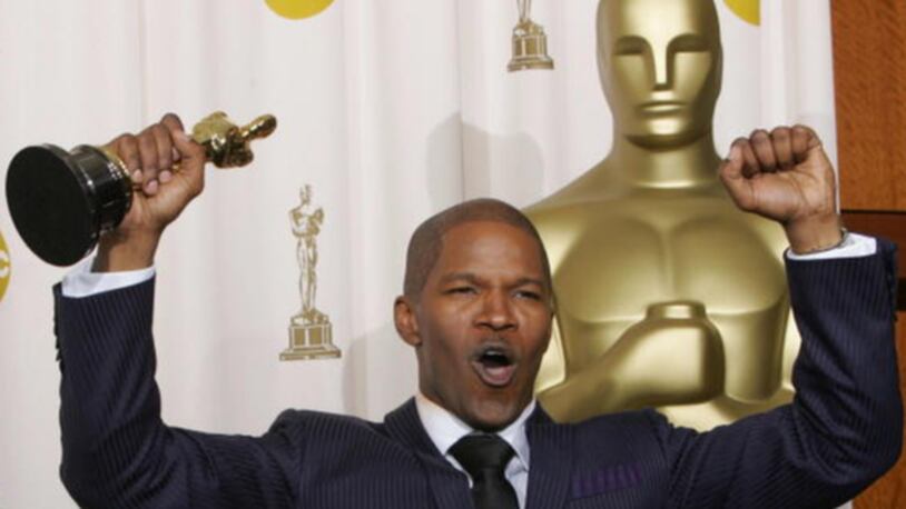 HOLLYWOOD, United States:  Best Actor Jamie Foxx pumps his fists, hoisting his trophy, at the Kodak Theater in Hollywood, California, 27 February, 2005, during the 77th Academy Awards. Foxx won for his performance in "Ray."  AFP PHOTO/ROBYN BECK  (Photo credit should read ROBYN BECK/AFP/Getty Images)