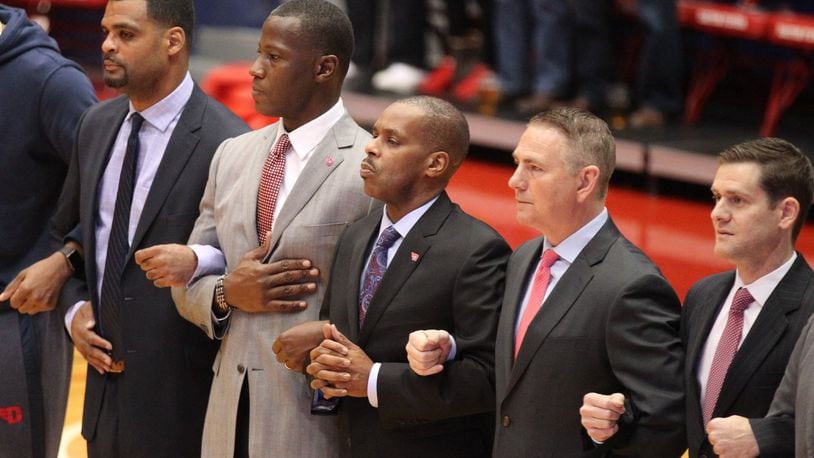 Dayton coaches, including Anthony Grant, second from left, stand for the national anthem before a game against North Florida on Wednesday, Nov. 7, 2018, at UD Arena. David Jablonski/Staff