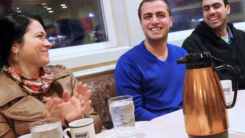 Dr. Mahmoud Dabbous, center, laughs as he and other local residents, including Dr. Gigi Sankary, left, and Ahmad Abbas, right, all originally from Syria celebrate together at the IHOP on Talmadge Road in West Toledo. A group of about 20 local residents, including many Syrian expatriates, meet weekly to get to know one another over coffee. Often they stay for hours, sometimes into the early morning, catching up with their new neighbors as they build community. On this particular Tuesday, the group was celebrating Dr. Dabbous’ news: he was cleared the begin the processes of certification to practice medicine in the U.S. Dr. Dabbous is general practitioner and Dr. Sankary is a dentist. Dr. Dabbous and Mr. Abbas have come America as an asylum-seekers, while Dr. Sankary is an American citizen, though her husband and children are not. The ongoing war in Syria has produced an international refugee crisis, and forced many of the country’s citizens to flee by other means, such as seeking asylum. The war has also divided families; Dr. Dabbous’ family continue to live in Syria, Dr. Sankary’s two adult daughters are stranded in Turkey and Mr. Abbas’ wife remains in Damascus. THE BLADE/KATIE RAUSCH