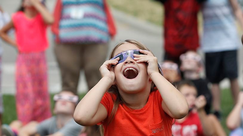 A young student at Horace Mann Elemantary seems amazed as the clouds break up revealing the solar eclipse on Aug. 21, 2017. The photo was among three by Staff Photographer Bill Lackey nominated for best feature photo. Bill Lackey/Staff