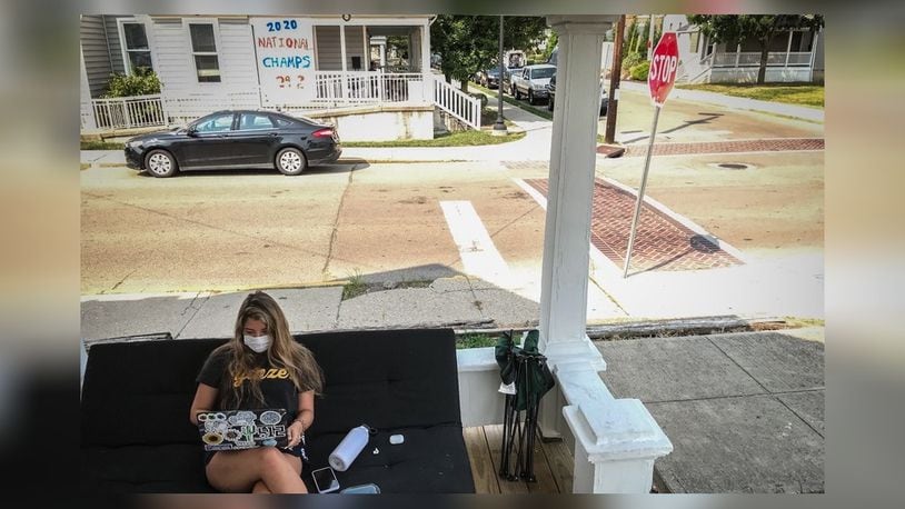 Bree Nurray, a University of Dayton senior from Pittsburgh, takes an online class on the front porch of her rental house on the campus Wednesday Aug. 26, 2020.