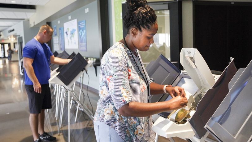 Montgomery County elections workers Lakesia McLemore, right, and Brandon Izor set up polling machines Monday at the Christian Life Center where voters from four Butler Twp. precincts will cast ballots Tuesday. CHRIS STEWART / STAFF