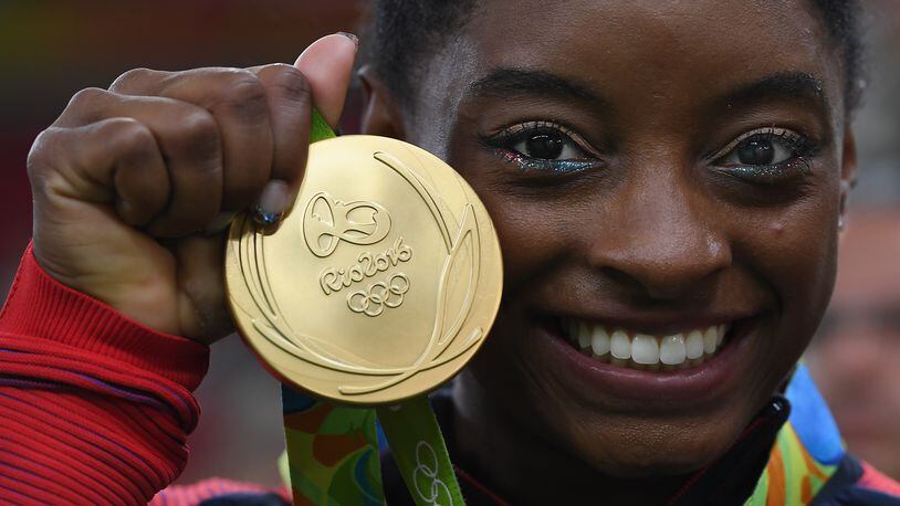 RIO DE JANEIRO, BRAZIL - AUGUST 09: Simone Biles of the United States poses for photographs with her gold medal after the medal ceremony for the Artistic Gymnastics Women's Team on Day 4 of the Rio 2016 Olympic Games at the Rio Olympic Arena on August 9, 2016 in Rio de Janeiro, Brazil. (Photo by Laurence Griffiths/Getty Images)