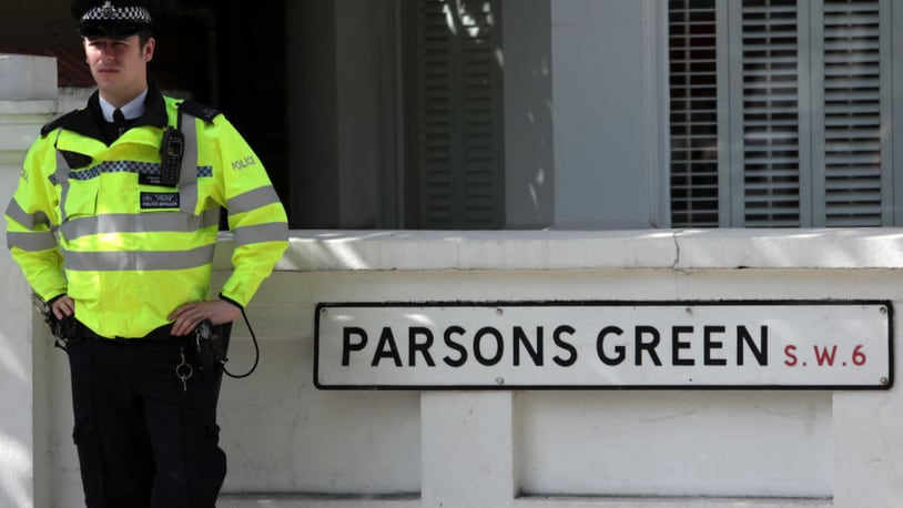 A police officer stands next to a street sign near Parsons Green Underground Station on Friday.