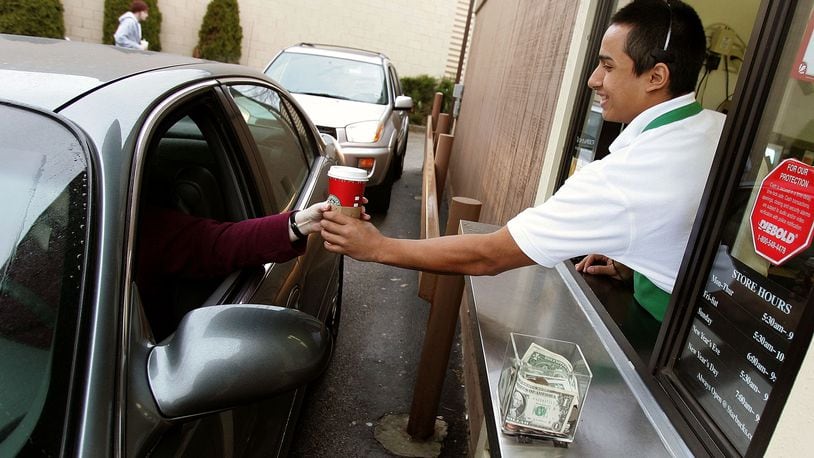 WHEELING, IL - DECEMBER 28:  Starbucks worker Freddie Arteaga assists a customer with her drink order at a Starbucks drive-thru December 28, 2005 in Wheeling, Illinois. Starbucks opened 354 drive-thru stores in the U.S. in the past year, which brought for the first time, the number of new drive-thrus to comprise more than half of all new Starbucks company operated stores opened nationwide.  (Photo by Tim Boyle/Getty Images)