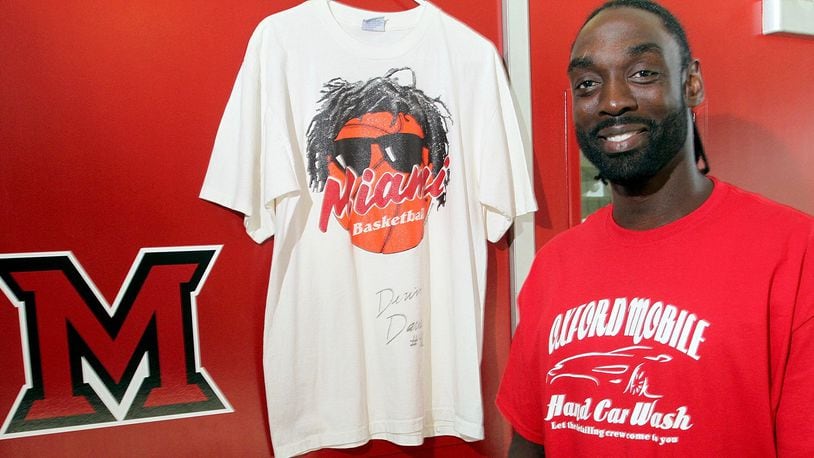 Devin Davis, a Miami University sports hall of fame member, with a shirt from his playing days, center, and wearing one for the local business he has started, at Millett Hall in Oxford Thursday, July 11, 2013.CONTRIBUTED PHOTO BY E.L. HUBBARD