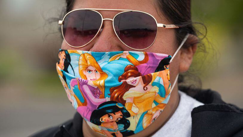 NACHES, WA - MAY 16: A demonstrator wears a Disney themed mask during a strike outside of Allan Brothers Fruit on May 16, 2020 in Naches, Washington. Workers from at least six fruit packing facilities in the Yakima County area have gone on strike to protest working conditions amid the COVID-19 pandemic.
