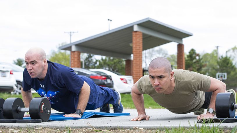 Airman 1st Class Michael Mannozzi (left), 88th Air Base Wing chaplain’s assistant, and Staff Sgt. Ronald Knox, Air Force Institute of Technology knowledge operator, do as many pushups as they can in a one-minute period during the All-Star Fitness Challenge at Wright-Patterson Air Force Base on April 15. Competitors had to do a series of exercises at four different stations. U.S. AIR FORCE PHOTO/WESLEY FARNSWORTH
