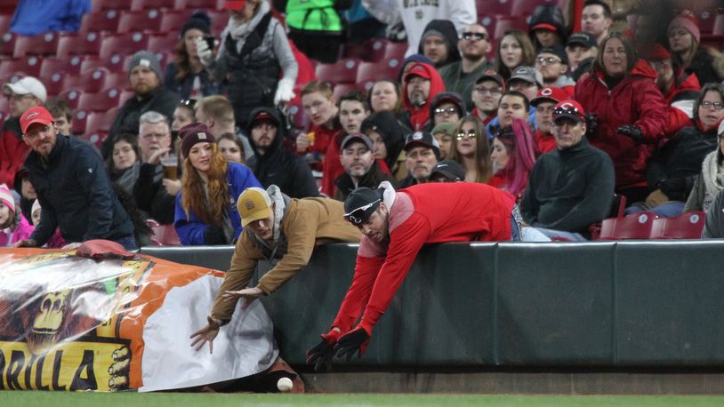 Fans try to catch a foul ball during a game between the Reds and Brewers on Monday, April 1, 2019, at Great American Ball Park in Cincinnati.