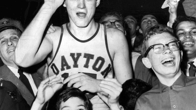 3-24-1962 NEW YORK: Big Bill Chmielewski, who led Dayton to a 73-67 victory over St. John's in the finals of the National Invitation Basketball Tournament, is mobbed by delirious fans at the end of the game. On his head is the trophy he received as the most valuable player. UPI TELEPHOTO