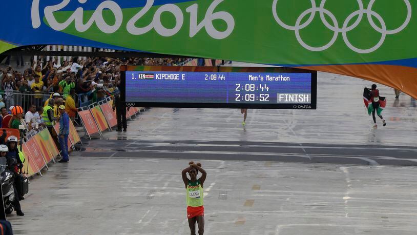 Ethiopia's Feyisa Lilesa crosses his arms as he crosses the finish line to win the silver medal in the men's marathon at the 2016 Summer Olympics in Rio de Janeiro, Brazil, Sunday, Aug. 21, 2016. (AP Photo/Luca Bruno)