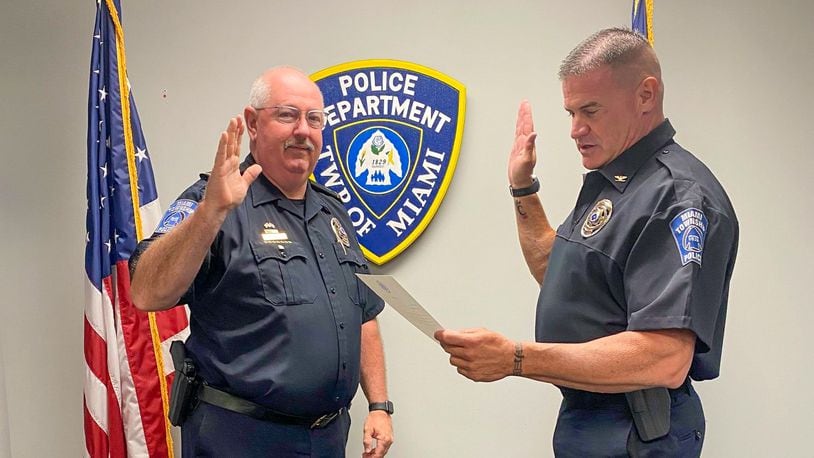 Miami Twp. Police Chief Charles Stiegelmeyer (right) swears in John Magill as the police department's assistant chief. The newly created role and those of two new lieutenant positions are aimed at helping the department increase its efficiency. CONTRIBUTED
