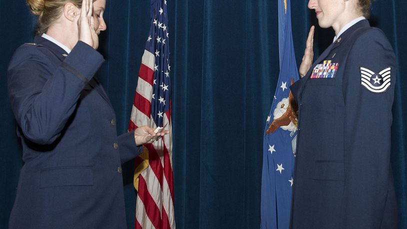 U.S. Air Force Capt. Nicole Tripputi, a contract negotiator with the 645th Aeronautical Systems Group, Big Safari, gives the oath of enlistment to her sister, Tech. Sgt. Jennifer Stem, 88th Aerospace medicine squadron ophthalmic technician, during a re-enlistment ceremony June 19 inside the auditorium of the Wright-Patterson Medical Center at Wright-Patterson Air Force Base. The two have been stationed together at WPAFB for the first time since August 2016. (U.S. Air Force photos/Michelle Gigante)
