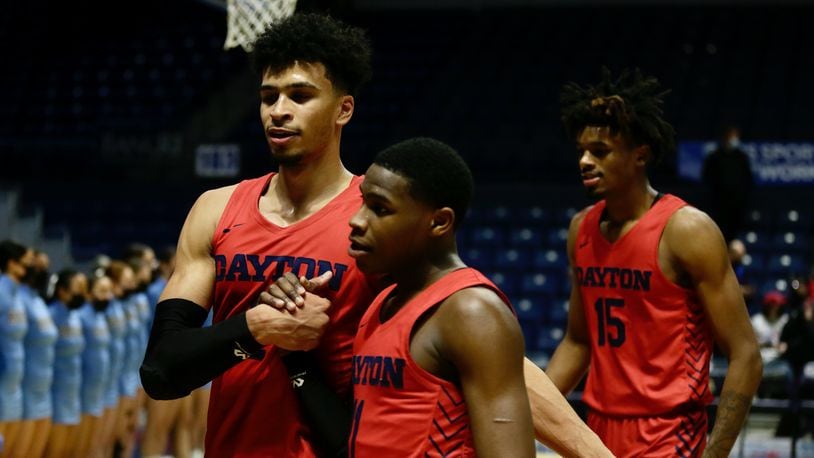 Dayton's Toumani Camara, left, and Malachi Smith, center, leave the court after a victory against Rhode Island on Monday, Feb. 14, 2022, at the Ryan Center in Kingston, R.I. David Jablonski/Staff