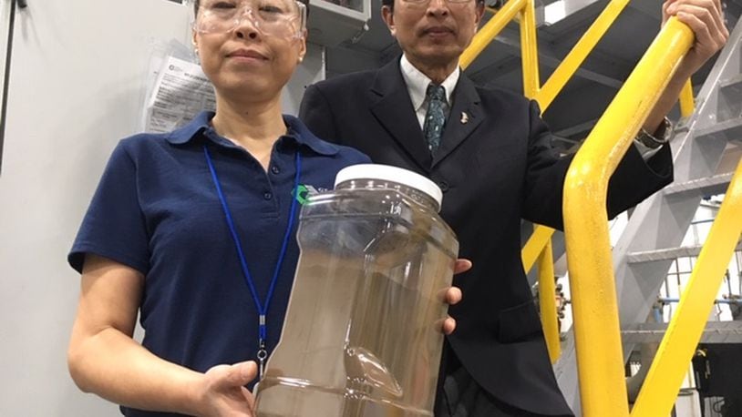 Global Graphene Group (G3) co-founders Aruna Zhamu (left) and Bor Jang, holding a jar of graphene material that will comprise a battery anode. G3 says graphene will help batteries of both smart phones and electric vehicles charge faster, last longer and dissipate heat more completely. This photo was taken at G3’s McCook Avenue production facility. THOMAS GNAU/STAFF