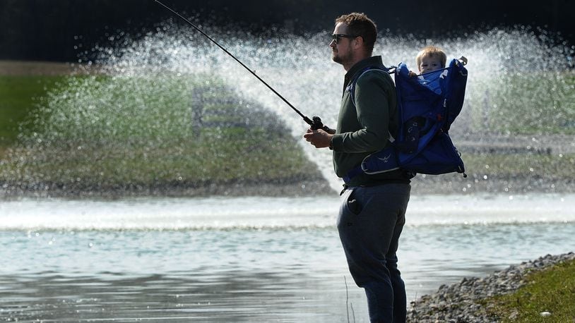 Jeremy Valentine along with his 10 month old son, Fisher, enjoy fishing Friday, March 29, 2024 at Miami View Park on Munger Road. MARSHALL GORBY\STAFF