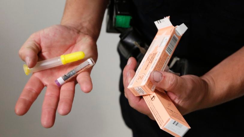 During a shift last year, Dayton Police Officer Joe Sheen replenished his supply of Narcan. CHRIS STEWART / STAFF