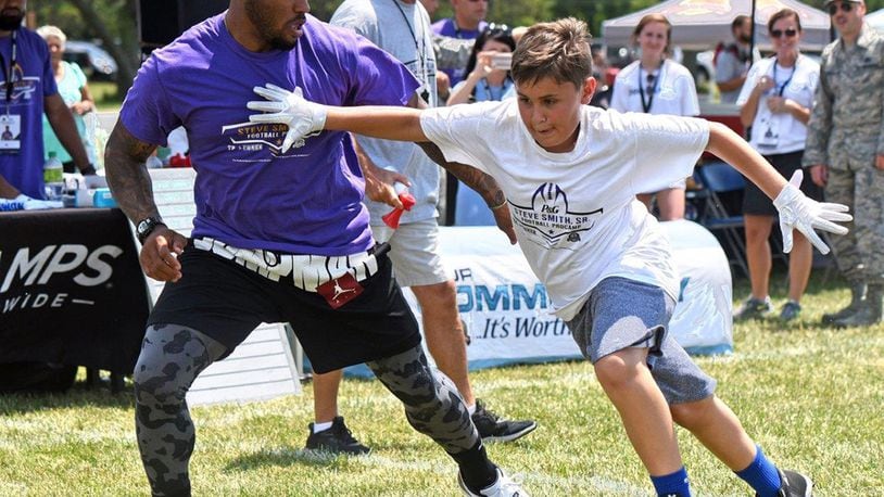 Steve Smith, former National Football League all-pro wide receiver with the Baltimore Ravens and Carolina Panthers football teams, instructs a young receiver on running a correct pass route during the NFL Football ProCamp clinic at Wright-Patterson Air Force Base July 9. The clinic, sponsored by the Defense Commissary Agency, was a 2-day event open to boys and girls in grades 1-8, who are dependents of active-duty, retirees and Department of Defense civilian employees. (U.S. Air Force photo/Al Bright)