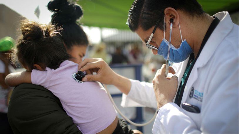 A Honduran mother holds her daughter, who fell ill, while she is examined by a doctor outside a shelter for migrants who are part of the so-called "migrant caravan" on November 21, 2018, in Mexicali, Mexico. A 7-year-old Guatemalan girl died of dehydration and septic shock Dec. 8, 2018, while in U.S. Border Patrol custody.