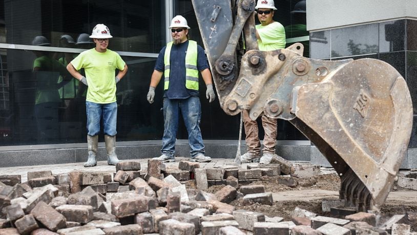 Workers replace the brick sidewalks around the Dayton Convention Center on 5th Street with concrete walkways Monday May 6, 2024. JIM NOELKER/STAFF