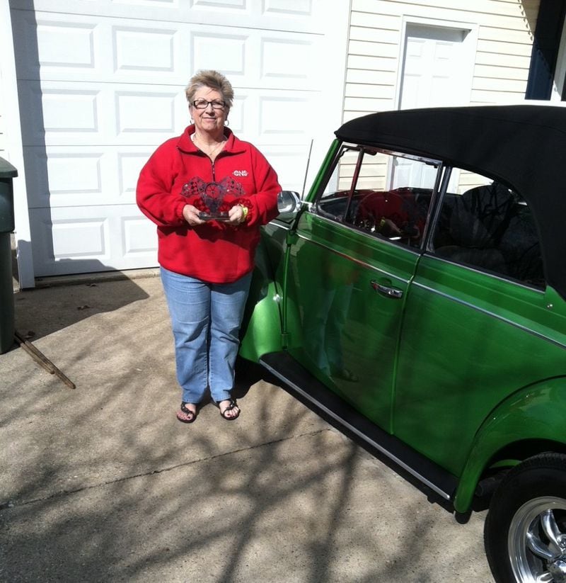 Sheila Sutton stands with her restored 1970 Volkswagen Beetle. Her husband gave it to her as a gift after her first retirement. CONTRIBUTED