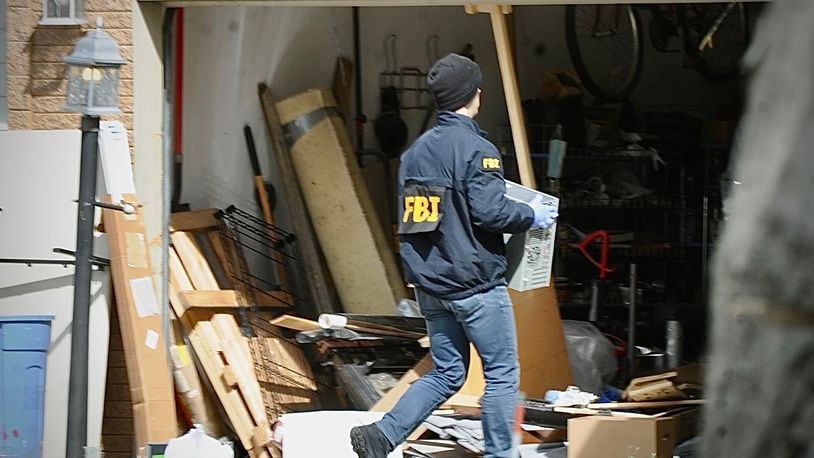 Several local law-enforcement agencies and the FBI go through a home on Barnhart Road in Troy Friday morning, April 5, 2024. MARSHALL GORBY \STAFF