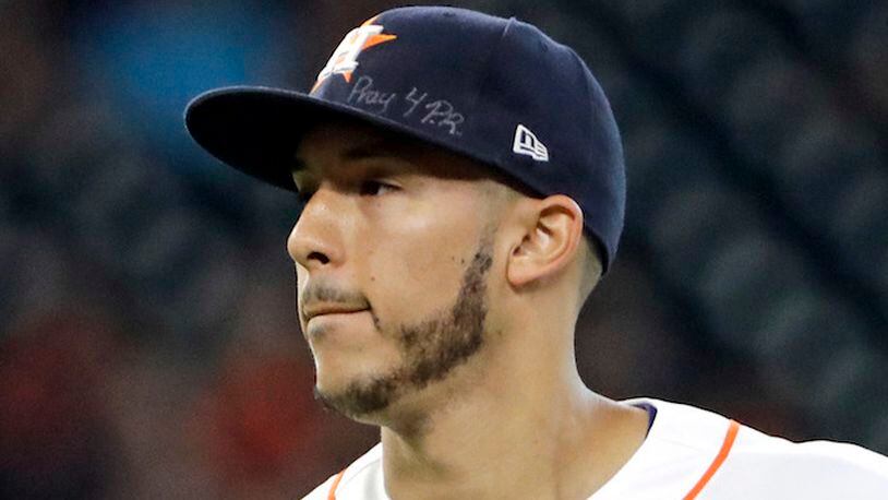 This is a Sept. 23, 2017, file photo showing Houston Astros shortstop Carlos Correa wears a message on his cap for those affected by the Hurricane in Puerto Rico during the second inning of a baseball game.  (AP Photo/David J. Phillip, File)