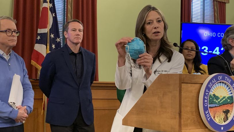 Ohio Department of Health Director Dr. Amy Acton, with Ohio Gov. Mike DeWine and Lt. Gov. Jon Husted, said on Sunday Ohio is facing a shortage of N95 and surgical masks needed to respond to the coronavirus pandemic. Laura Bischoff/Staff