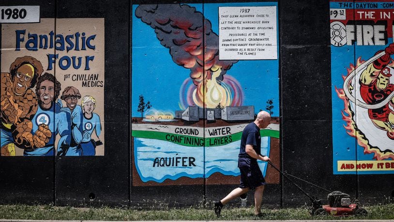 Dayton Firefighter Mike Brown cuts grass in front of a a mural depicting the history of Dayton firefighting on Buckeye St. Friday June 24, 2022.  On Saturday at 1:00p.m. there will be a dedication of the mural and the public is invited. JIM NOELKER/STAFF